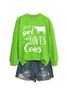 Detail of bright green sweatshirt featuring 'JUST A girl WHO LOVES Cows' print and denim shorts