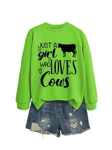 Detail of green sweatshirt with JUST A girl WHO LOVES Cows print and cow motifs