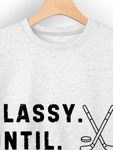 Detail of the light grey crewneck sweatshirt featuring a hockey theme graphic print
