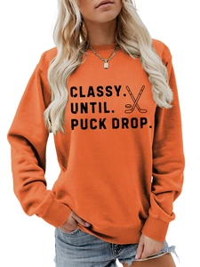 Detail view of orange hockey sweatshirt featuring Classy Until Puck Drop text and graphics
