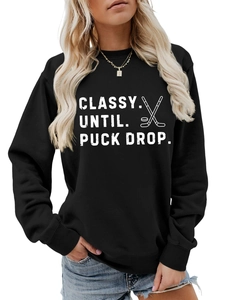 Detail of white screen-printed CLASSY UNTIL PUCK DROP hockey text on a black sweatshirt