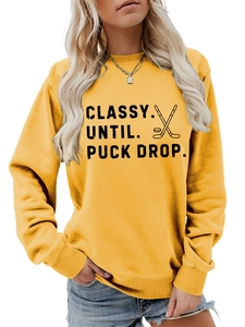 Detail of ribbed cuffs and hockey print on bright yellow crewneck sweatshirt