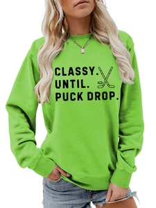 Detail of light green crewneck sweatshirt with hockey sticks and puck graphic print