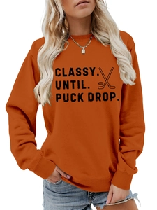 Close-up of burnt orange crewneck sweatshirt with Classy Until Puck Drop hockey print