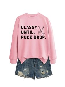 Detailed flat lay of pink hockey sweatshirt with black letters and denim shorts