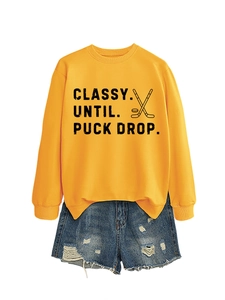Detail of yellow Classy Until Puck Drop sweatshirt paired with distressed denim shorts
