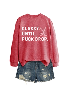 Flat lay of a red heathered sweatshirt with Classy Until Puck Drop print and ripped denim shorts