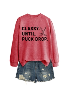 Detail of red crewneck sweatshirt with hockey slogan and distressed blue denim shorts