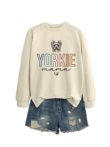 Detail eines beigen Sweatshirts mit Yorkie-Mama-Print und Distressed-Denim-Shorts kombiniert