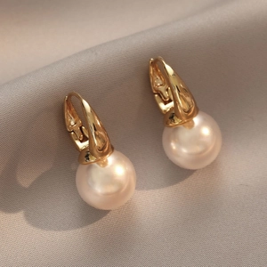 Élégantes boucles d'oreilles perles d'eau douce avec fermoirs dorés sur tissu gris