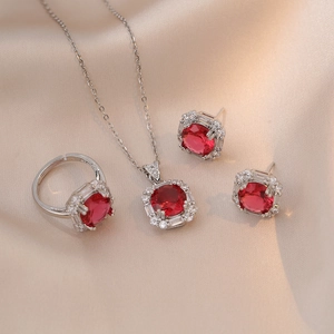 Elegant silver jewelry set with round red gemstones and sparkling crystal accents