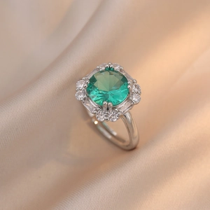 Retro emerald green ring with halo zircon stones on a champagne silk background
