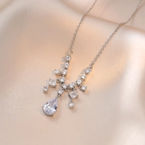 Élégant collier en argent avec pendentif en zircon sur fond de soie couleur champagne