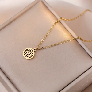 Titanium steel gold necklace with a round Fu character pendant on a jewelry box