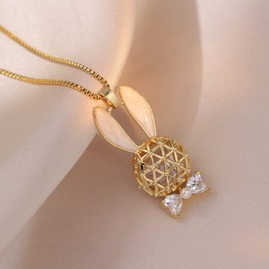 Golden hollow rabbit necklace with heart zircon and pearl on champagne silk background