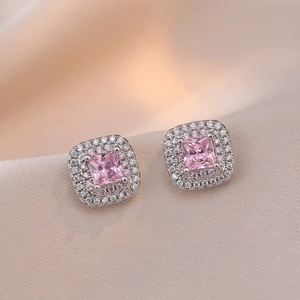 Elegant silver square earrings with pink zircon stone on champagne satin background