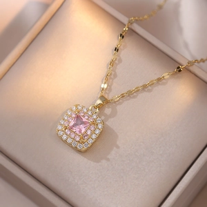 Macro shot of gold square necklace pendant with pink stone and halo crystal setting