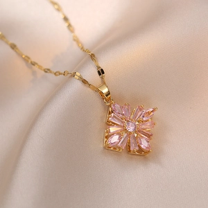 Detailed macro view of pink zircon rotating flower pendant on a fine gold chain