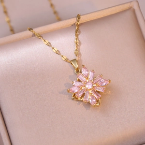 Detail of pink zircon flower pendant with gold plating on a delicate chain in a jewelry box