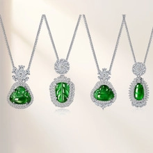 Detailed view of four emerald green pendants with silver settings and halo diamonds