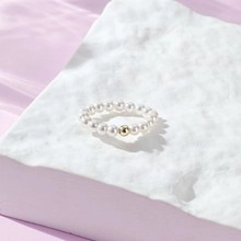 Detail of S925 silver beaded ring with white freshwater pearls and golden orb accent