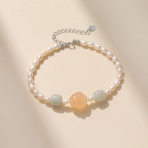 Détail du pendentif en argent S925 et agate sculptée sur un bracelet en perles blanches