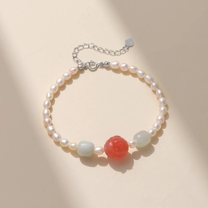 Détail du bracelet en perles d'eau douce avec fleur d'agate rouge et breloque cœur