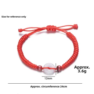 Macro view of braided red rope bracelet with white chalcedony charm and adjustable knots