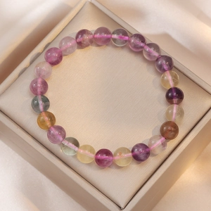 Colorful natural fluorite bead bracelet with purple and green stones on silk background
