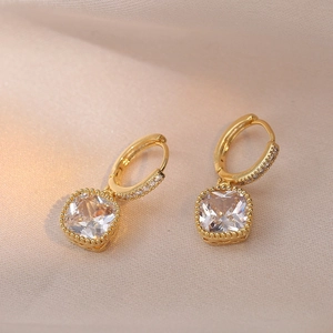 Elegant gold hoop earrings with square cubic zirconia drops on beige silk background