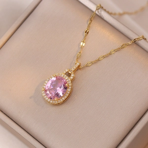 Détail macro du collier pendentif goutte rose avec halo de diamants et boîte à bijoux