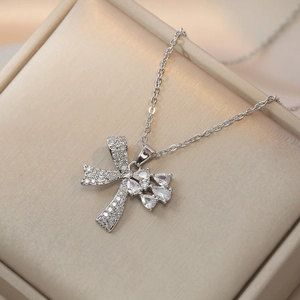 Élégant collier noeud argenté avec cristaux gouttes sur un coffret à bijoux beige