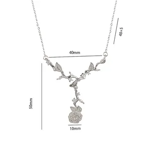 Collier liane argentée avec feuilles en zircon et pendentif fleuri sur fond blanc