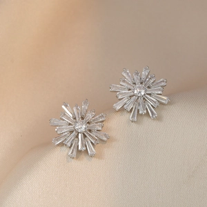 Boucles d'oreilles flocon de neige avec zircons sur velours de luxe couleur champagne
