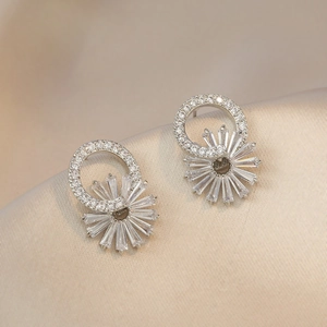 Boucles d'oreilles soleil en argent et zircons sur fond de soie champagne chic