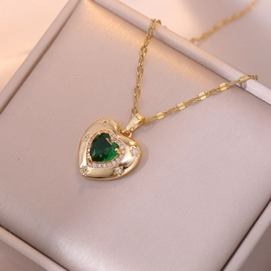 Emerald heart pendant necklace with gold chain and star accent in a jewelry box