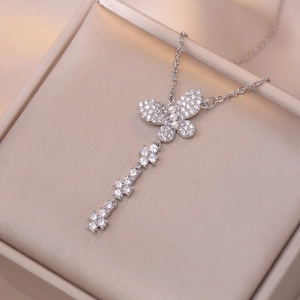Collier papillon élégant avec zircons et perles sur boîte à bijoux en soie beige