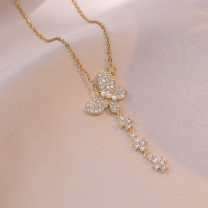 Collier papillon doré avec perles et franges en zircon brillant sur fond de soie