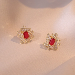 Elegant geometric earrings with red zircon center and white stones on champagne silk