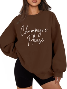 Dettaglio di una felpa oversize marrone scuro con stampa Champagne Please