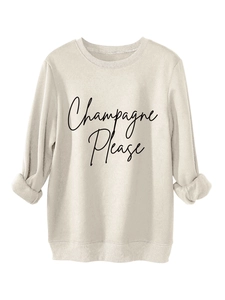 Dettaglio della stampa Champagne Please e del polsino a coste sulla felpa beige felpata