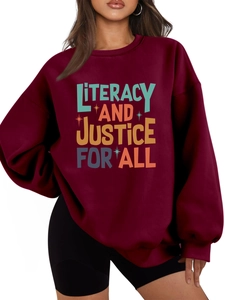 Detail of colorful literacy and justice text print on burgundy oversized sweatshirt