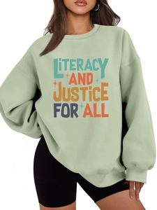 Detail view of the colorful Literacy and Justice for All print on a green sweatshirt
