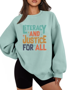 Detail of mint green sweatshirt with 'LITERACY AND JUSTICE FOR ALL' print and knit texture