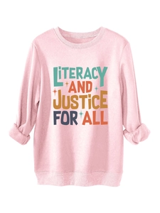 Close-up of pink fleece sweatshirt showing LITERACY AND JUSTICE FOR ALL graphic and ribbed cuffs