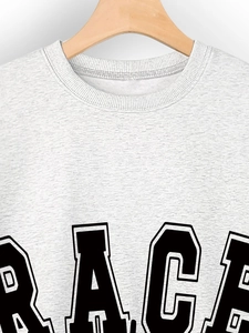 Close-up of light gray cotton sweatshirt featuring black GRACE block letter printing
