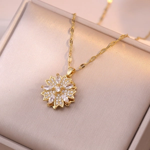 Detail of a rotating golden sunflower necklace with sparkling zircon stones in a gift box