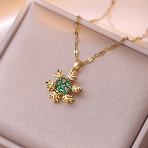Détail macro d'un pendentif flocon de neige rotatif avec zircon émeraude et boîte