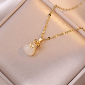 Minimalist lucky bag pendant necklace with gold chain and translucent cat eye stone