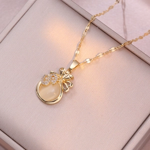 Détail du pendentif sac d'argent doré avec œil de chat et symbole dollar